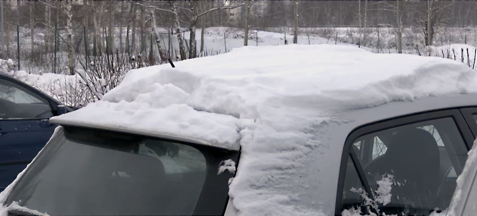 Automašīna ar biezu sniega kārtu uz jumta