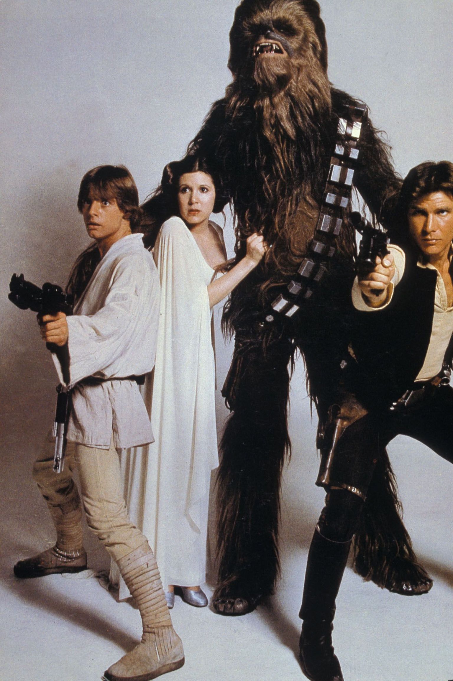 Mark Hamill Luke Skywalkerina, Carrie Fisher printsess Leiana, Chewbacca ja Harrison Ford Han Solona 1977. aastal reklaamplakati jaoks poseerimas