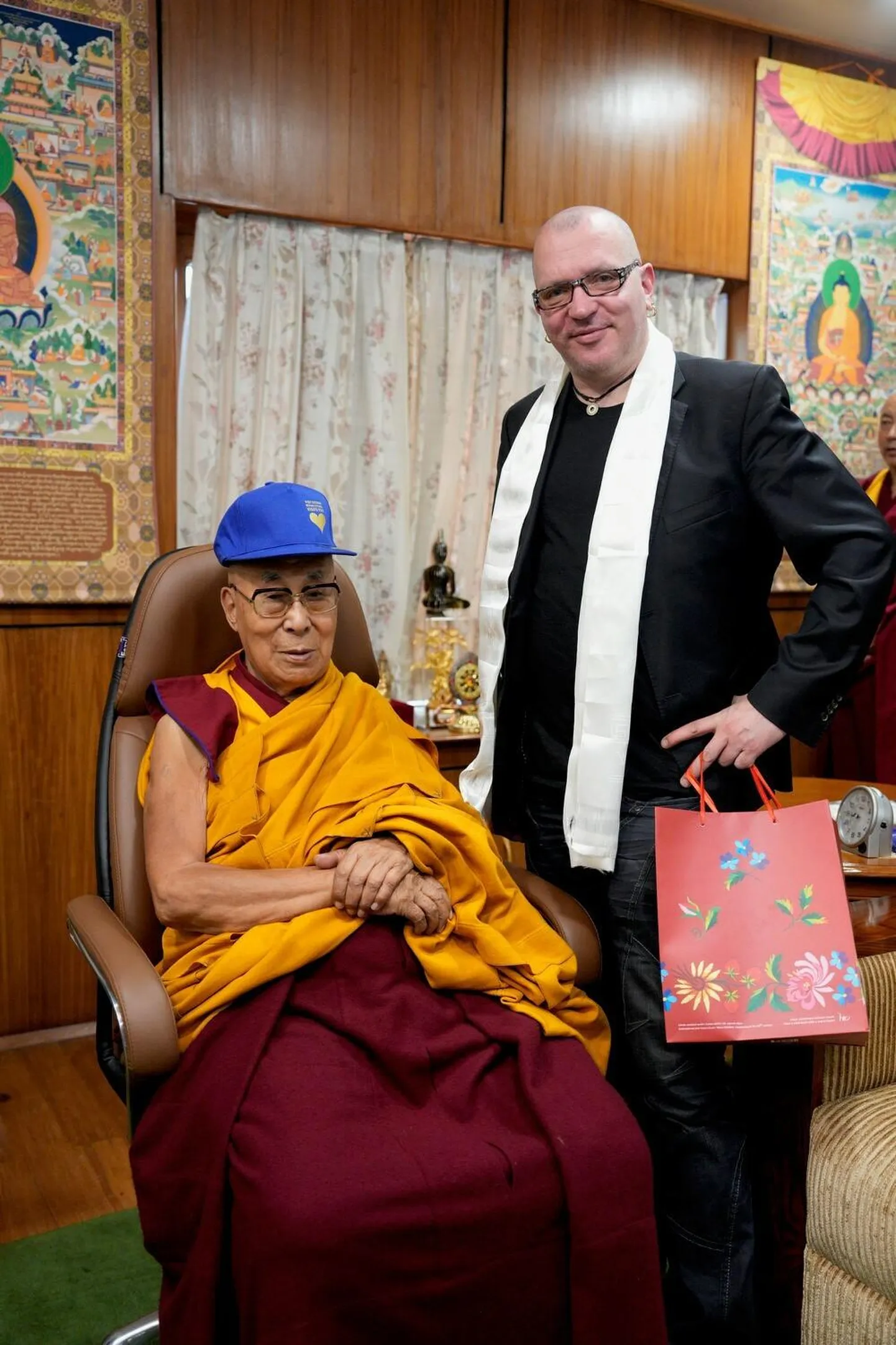 Dalai-laama eestlaste kingitud nokatsiga. Kõrval seisab riigikogu Tiibeti toetusrühma esimees Juku-Kalle Raid.