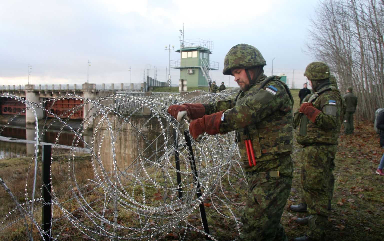 Военнослужащие Сил обороны устанавливают проволочное заграждение на границе Эстонии в Нарве.