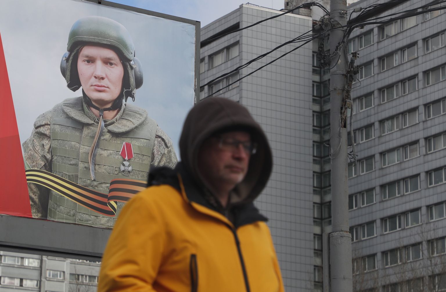 Mees kõnnib Moskvas Vene armeed toetava plakati ees.