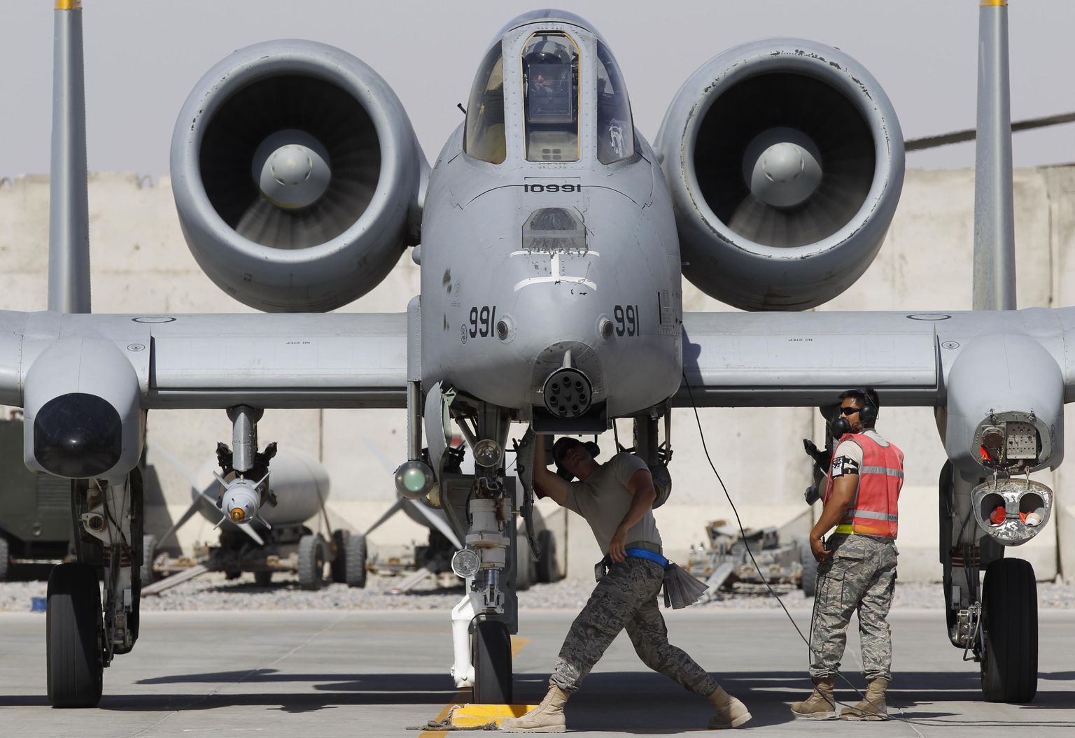 U.S. Air Force ground staff members check on an A-10 Thunderbolt II fighter-jet from the 81st Expeditionary Fighter Squadron after its landing at Kandahar Air Field in this September 2, 2010 file photo. The Pentagon said on February 24, 2014 it would shrink the U.S. Army to pre-World War Two levels, eliminate the popular A-10 aircraft and reduce military benefits in order to meet 2015 spending caps, setting up an election-year fight with the Congress over national defense priorities.  REUTERS/Oleg Popov/Files    (AFGHANISTAN - Tags: CONFLICT MILITARY TRANSPORT POLITICS)