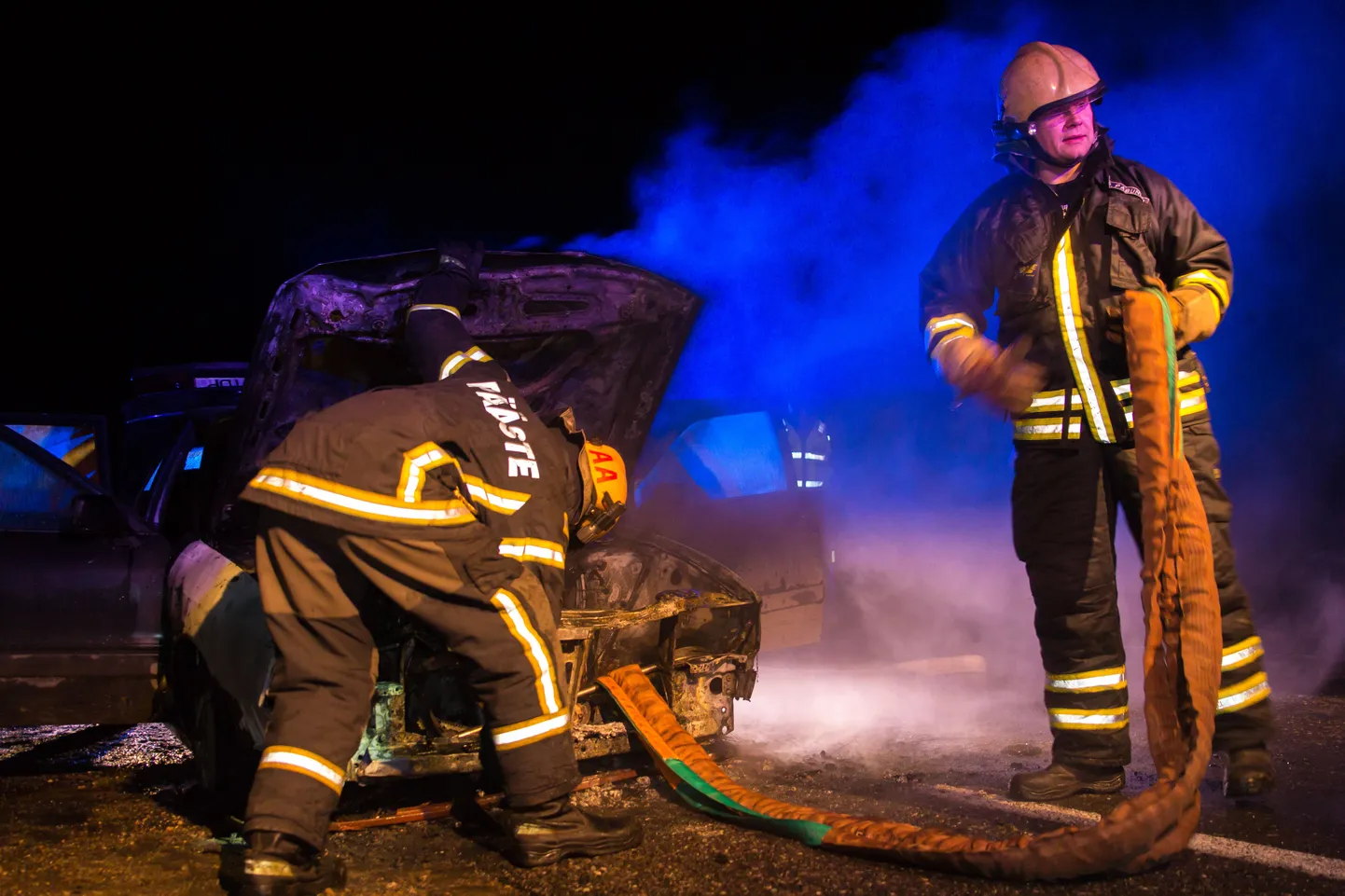 Päästjad kustutavad põlevat autot.
