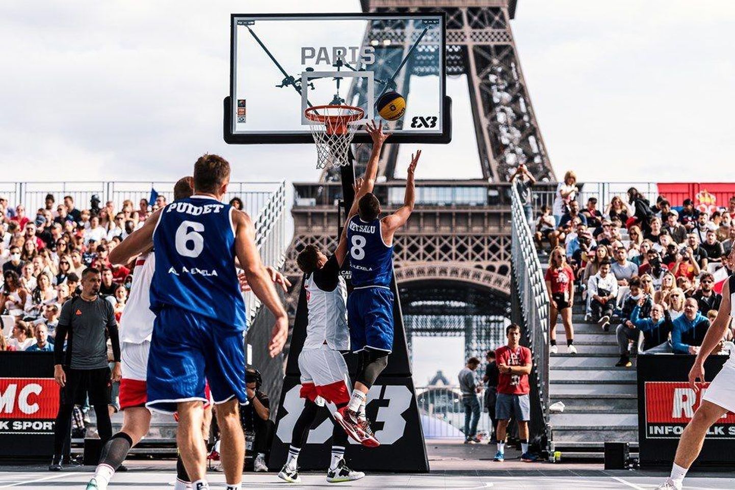 Eesti korvpallurid võitlevad Eiffeli torni all peetavas EMi veerandfinaalmängus Venemaaga. Korvi ründab Oliver Metsalu (nr 8), eemalt jälgib olukorda Jaan Puidet.