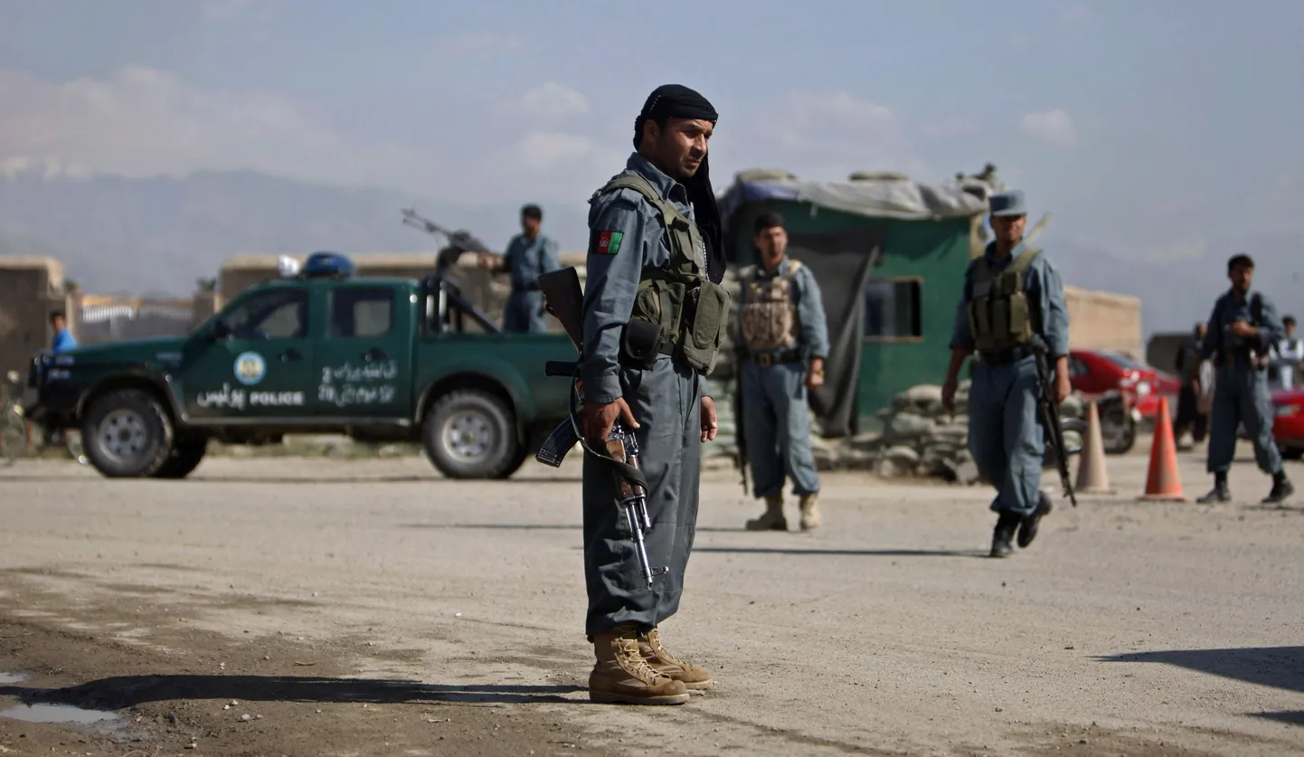 Афганский полицейский контролирует обстановку на дороге к базе Баграм.