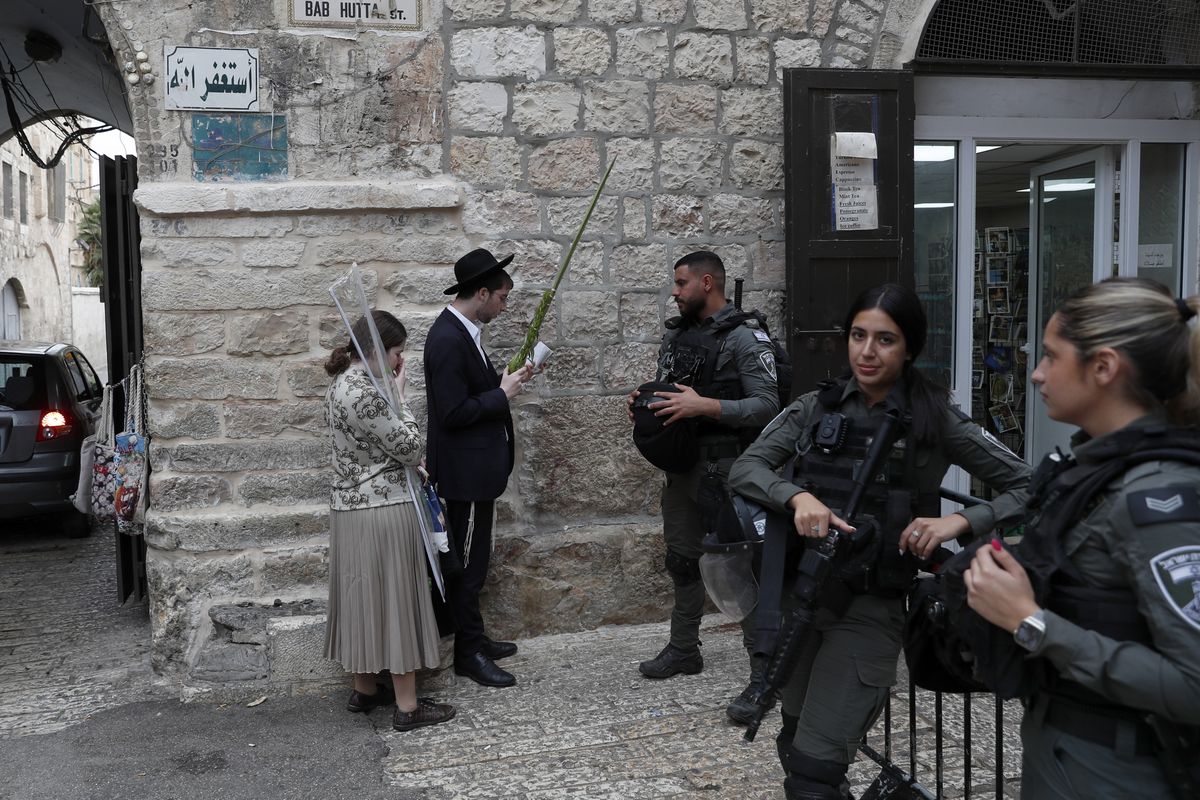 Ультраортодоксальные евреи молятся у ворот Баб-Хутта, ведущих к мечети аль-Акса, во время Праздника кущей в Старом городе Иерусалима, 4 октября 2023 года.
