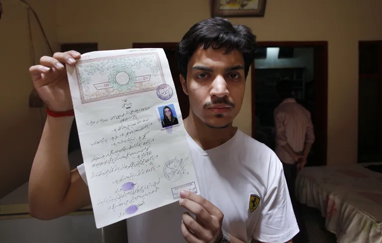 Hassan Khan näitamas enda ja oma naise Zeenat Rafiqi abielutunnistust