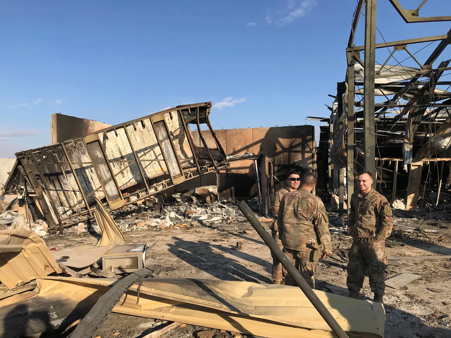 U.S. soldiers stand at the site where an Iranian missile hit at Ain al-Asad air base in Anbar province.