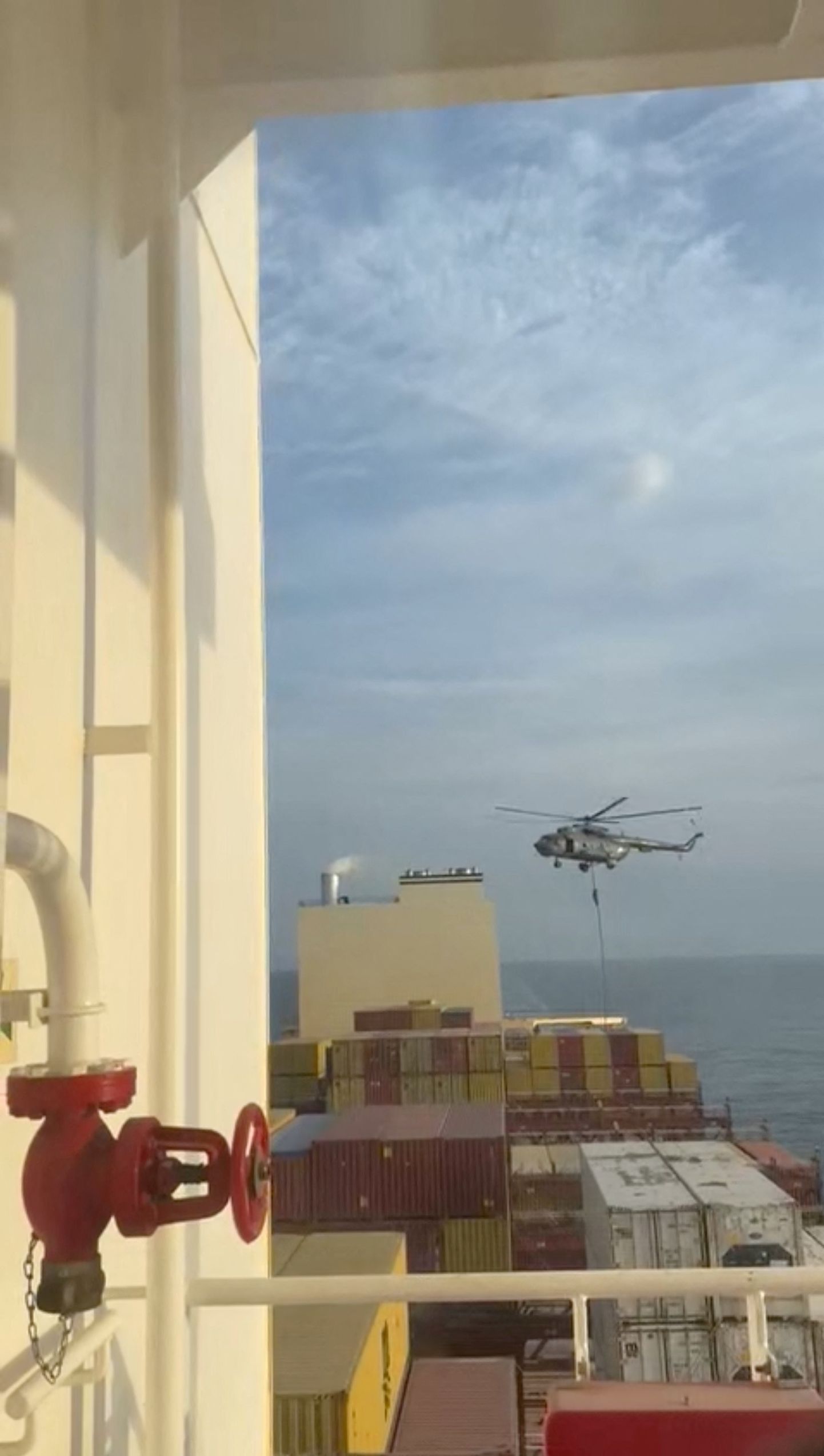 An official slides down a rope during a helicopter raid on MSC Aries ship at sea in this screen grab obtained from a social media video released on April 13, 2024.