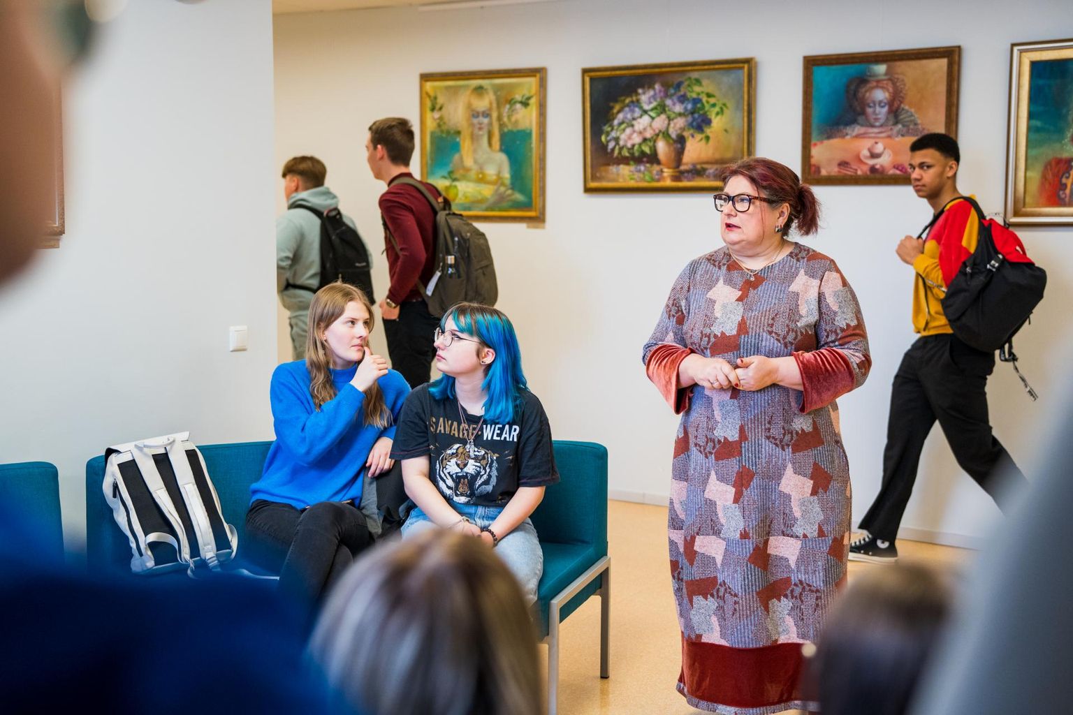 Tiina Ojaste annab õpilastele kunstitundi oma maalide näitusel “Nähtamatu ja nähtava piiril” Pärnu Koidula gümnaasiumis.
