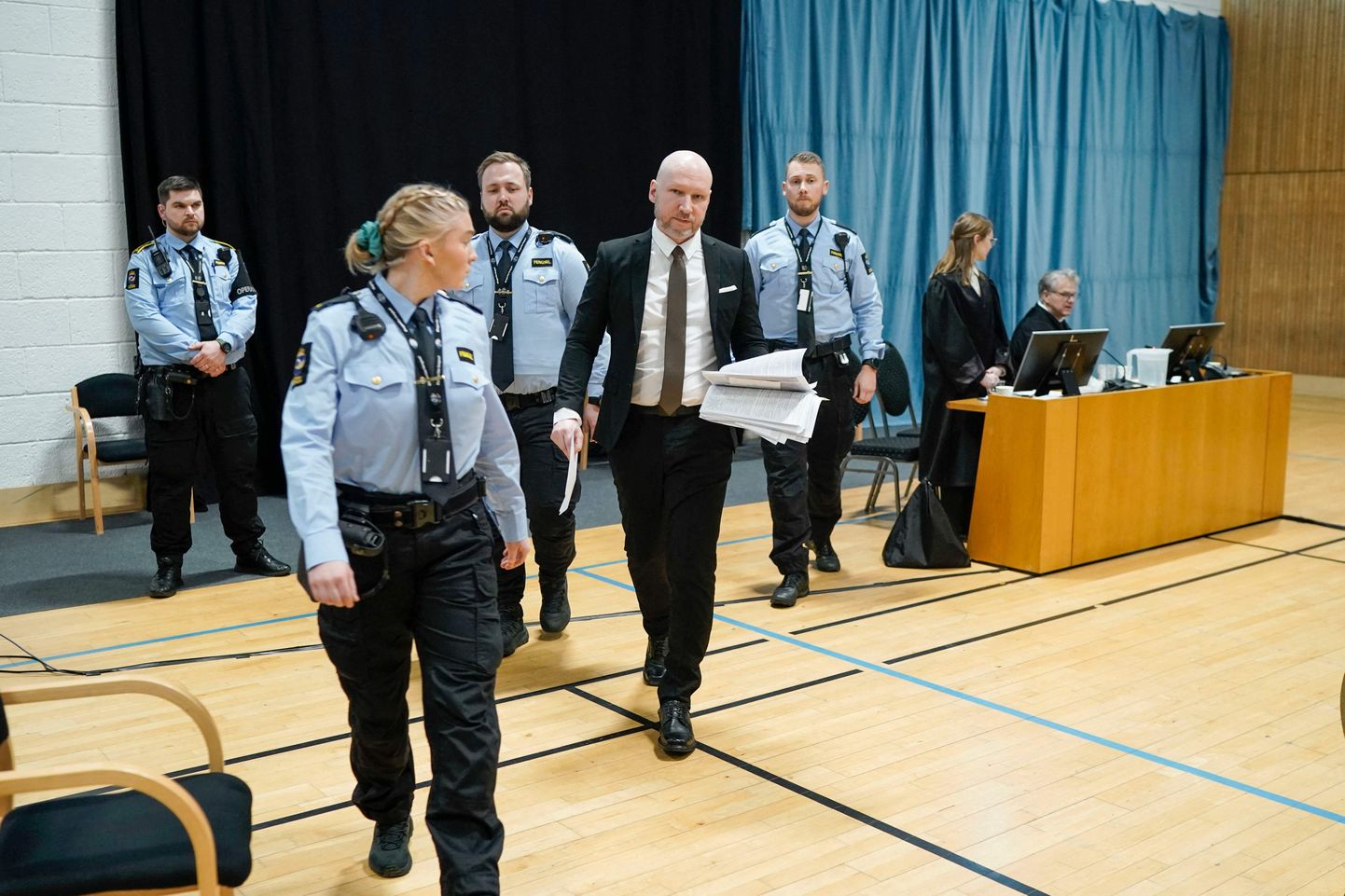 Norra massimõrvar Anders Behring Breivik saabumas politseinike saatel kohtusaali.