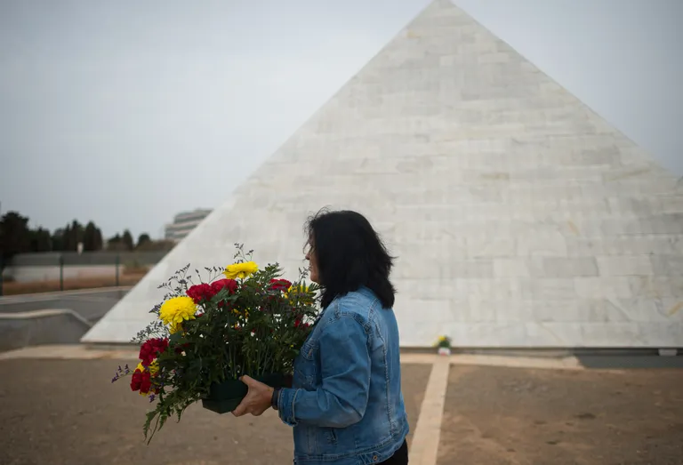 Женщина возлагает цветы к мемориалу жертв режима Франческо Франко на кладбище Сан Рафаэль в Малаге. День Всех Святых, 31 октября 2022 года.