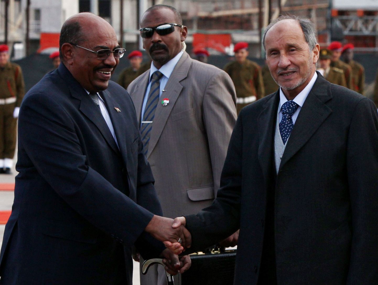 Liibüa üleminekunõukogu juht Mustafa Abdel Jalil (paremal) surumas Tripolis kätt Sudaani presidendi Omar al-Bashiriga.