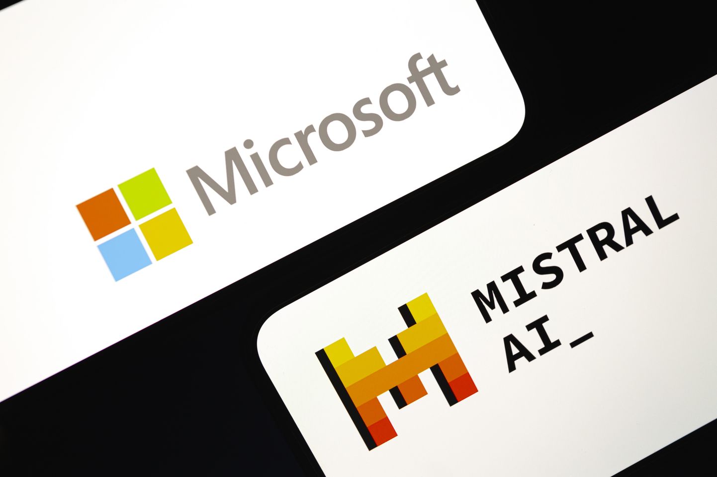 Microsofti ja Mistral AI logod nutitelefoni ekraanil