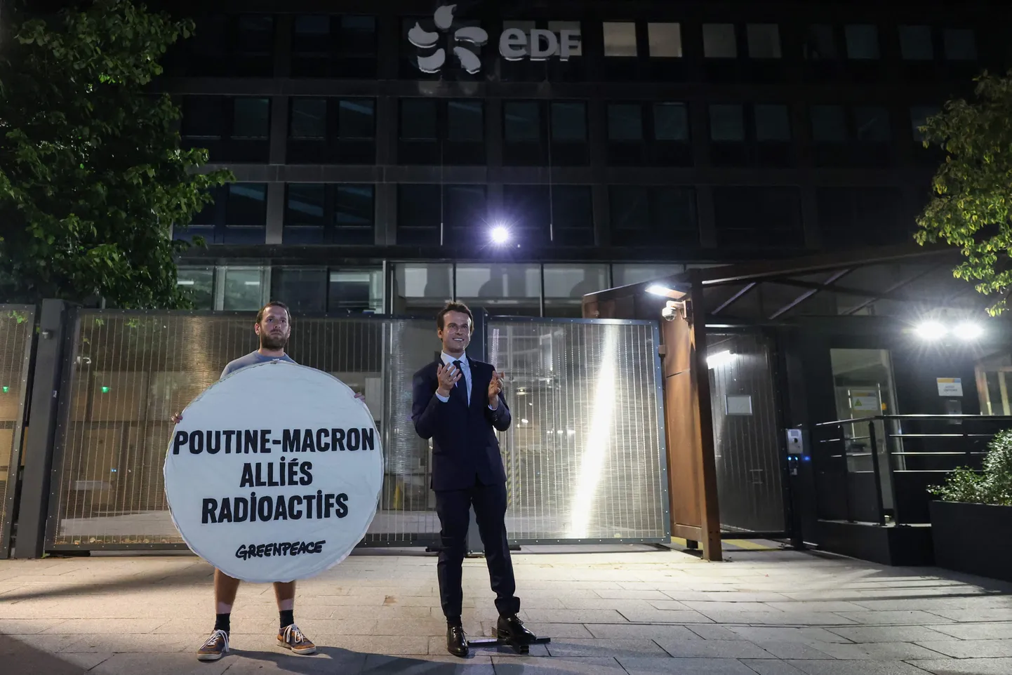 Greenpeac’i aktivist teispäeval Pariisis energiafirma EDFi peakorteri juures koos Emmanule Macroni vahakuju ja sildiga, mis teatab: «Putin-Macron radioaktiivsed liitlased».