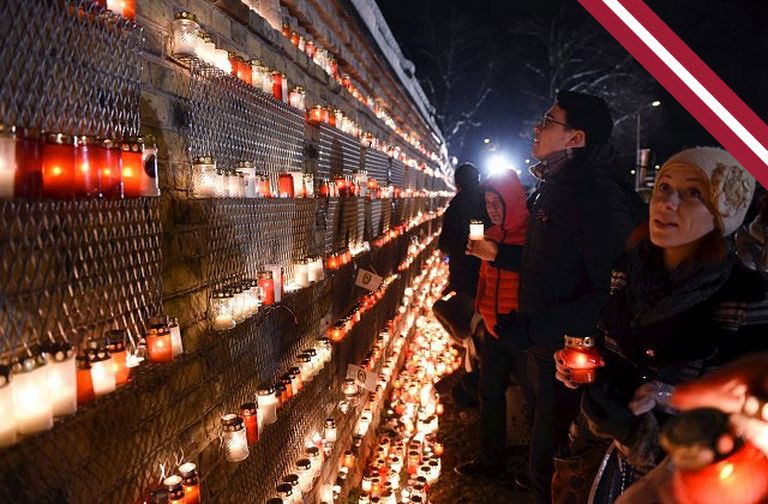 Par godu Lāčplēša dienai, cilvēki noliek svecītes pie Rīgas pils mūra 11.novembra krastmalā