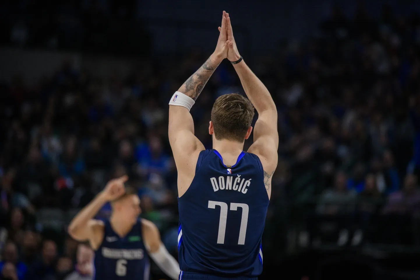 Luka Doncic (nr 77) aplodeerib Kristaps Porzingise korvile.