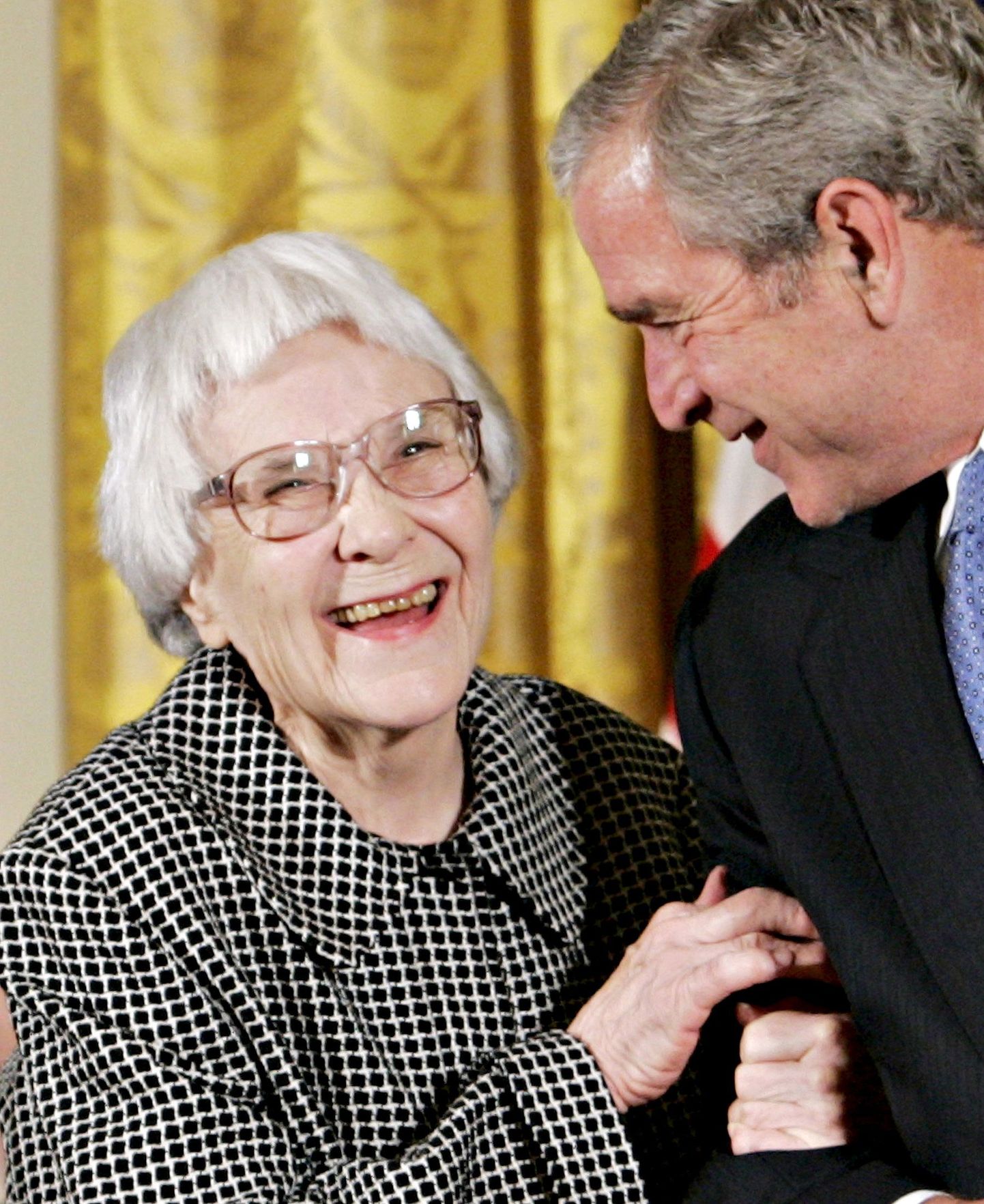 U.S. President George W. Bush smiles before awarding the Presidential Medal of Freedom to American novelist Harper Lee (L) in the East Room of the White House, Washington, in this November 5, 2007 file picture. Lee, who wrote one of America's most enduring literary classics, "To Kill a Mockingbird," about a child's view of right and wrong and waited 55 years to publish a second book with the same characters from a very different point of view, has died at the age of 89. REUTERS/Larry Downing/Files TPX IMAGES OF THE DAY