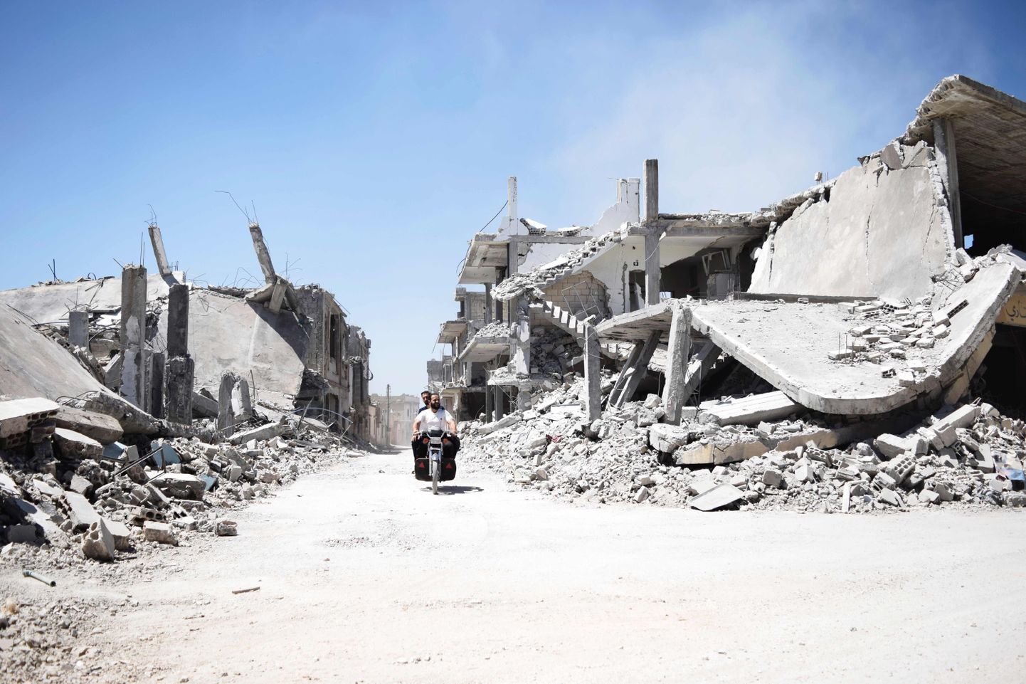 Süüria mehed eile Homsi linna lähistel õhurünnakute tõttu tekkinud rusude vahel.