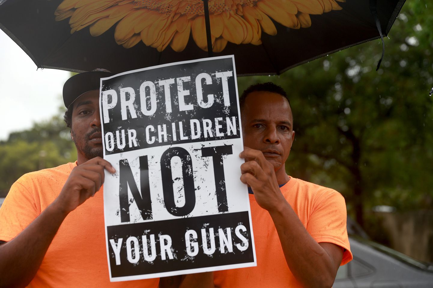 Protesteerijad plakatiga "Kaitse meie lapsi, mitte meie relvi."
