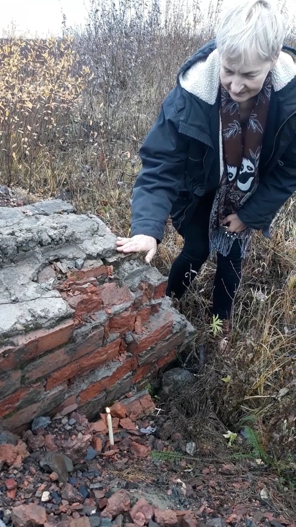 У здания бывшего кирпичного завода Аннели зажгла свечу. Отец вспоминал, что работа на кирпичном заводе была страшнее, чем на шахте.