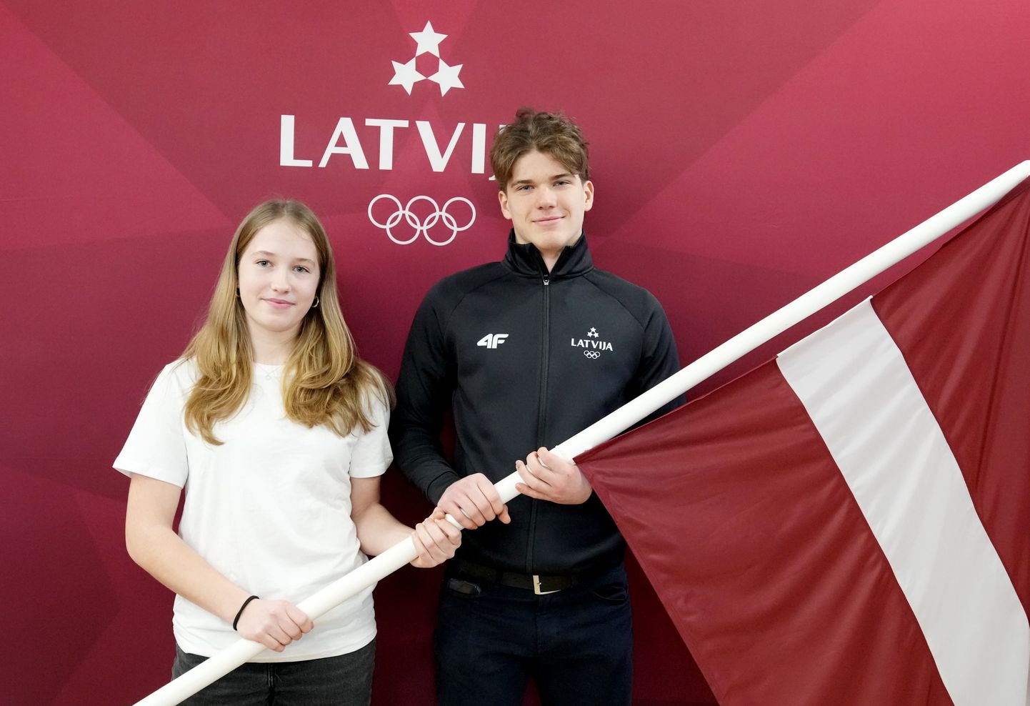Latvijas karognesēji - bobslejiste Amēlija Kotāne un hokejists Olivers Mūrnieks