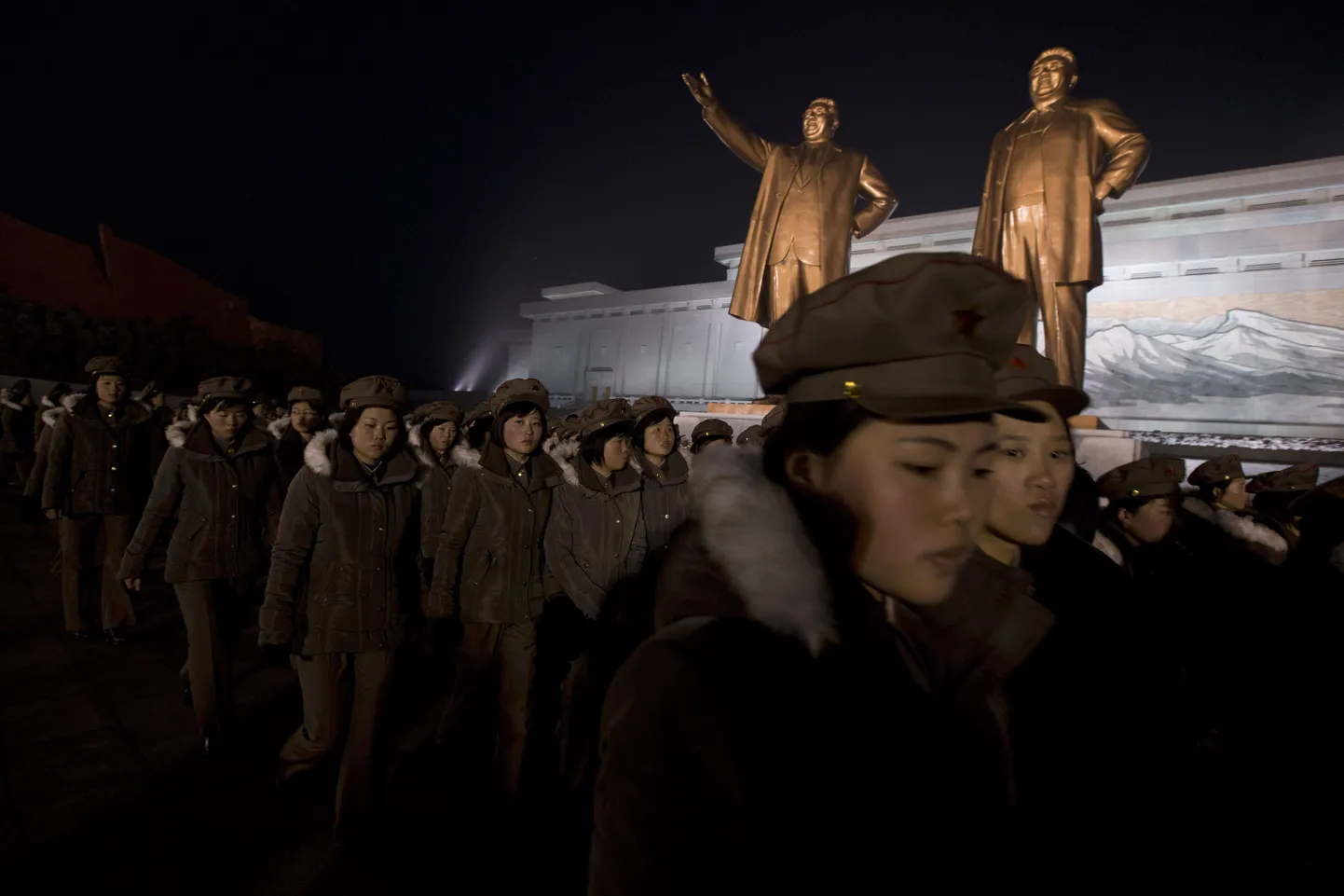 Mundris põhjakorealased eile Kim Jong-ilile ja tema riigi rajajast isale Kim Il-sungile pühendatud monumentide juures.
