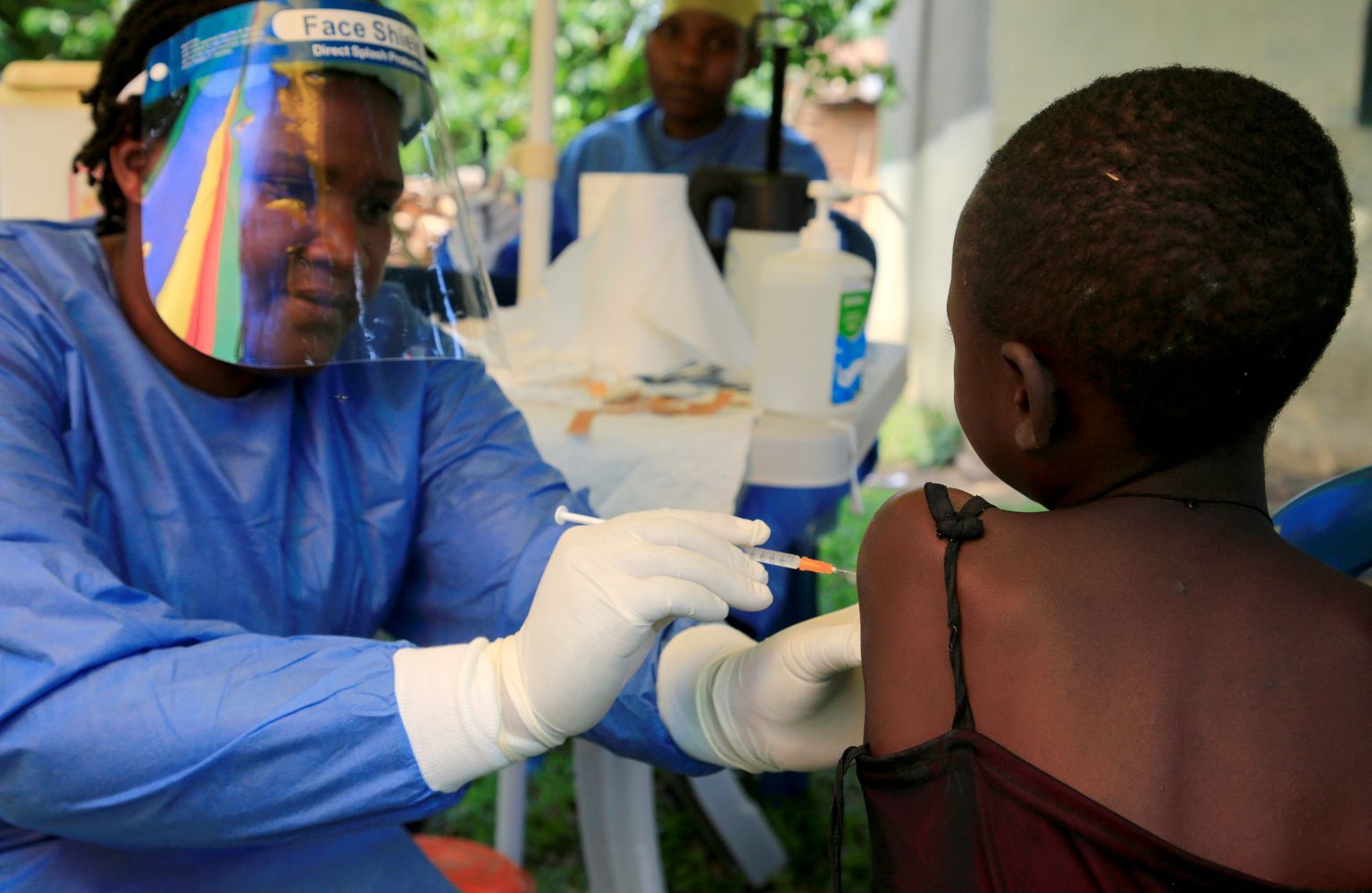 Uganda tervishoiutöötaja ebolavaktsiini süstimas.