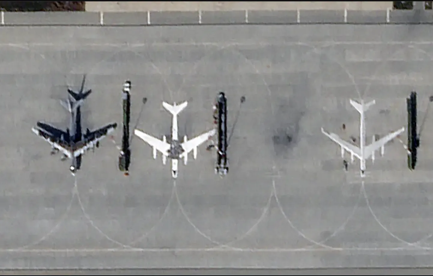 На спутниковых снимках видно, что на главной базе бомбардировщиков - авиабазе Энгельс, известной также как Энгельс-2, - Россия раскрашивает силуэты стратегических бомбардировщиков.