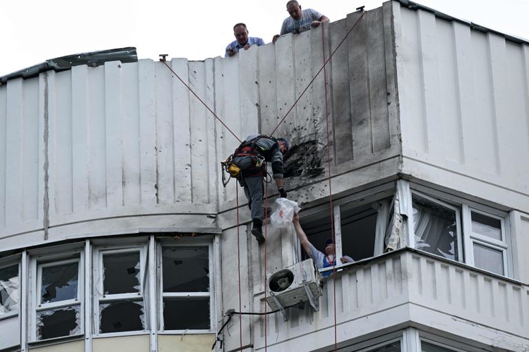 Специалист осматривает поврежденный фасад многоэтажного жилого дома после сообщения об атаке беспилотника в Москве 30 мая 2023 года.