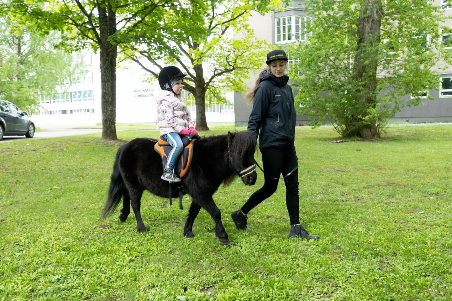 Liisi Prits talutab poni Melonit, kelle seljas istub 3-aastane Alisandra.