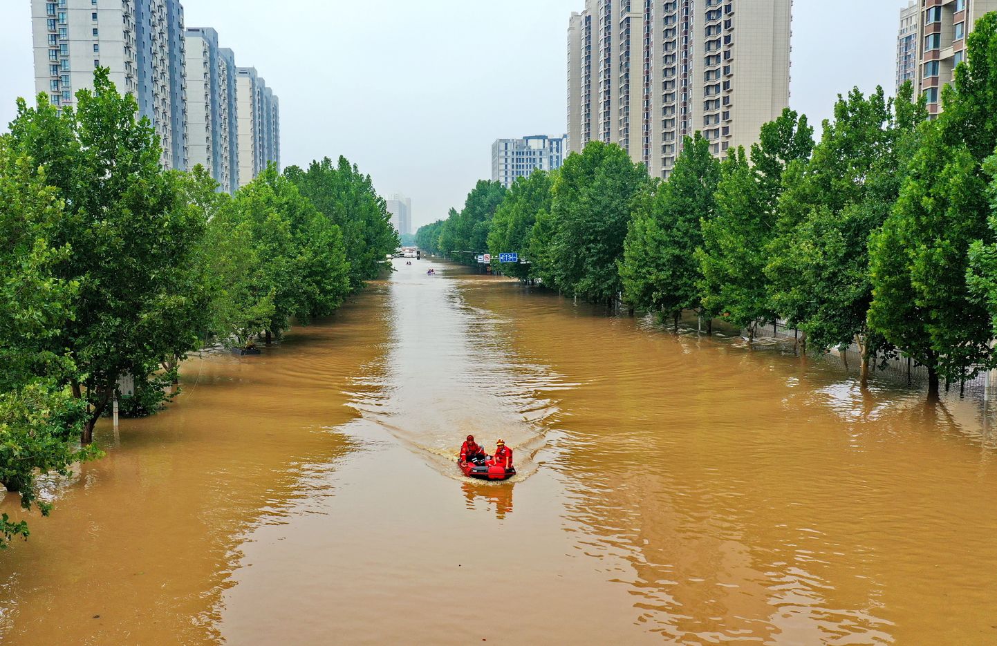 Inimesed liiklemas paatidega Pekingi naaberlinna Zhouzhou üleujutatud tänaval.