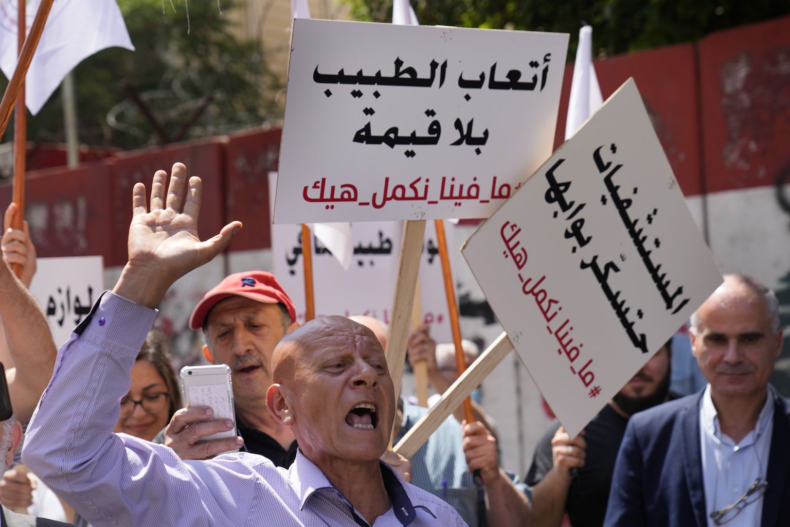 Meditsiinitöötajad protestimas Liibanoni keskpanga ees Beirutis käes araabiakeelsed plakatid loosungiga: «Arstide tasustamine on väärtusetu, haiglad sulgevad oma uksed, me ei saa nii jätkata.»