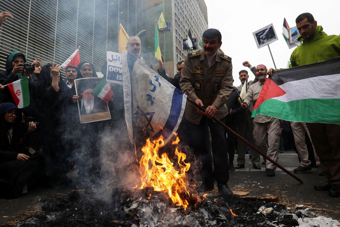 Житель Тегерана сжигает израильский флаг во время демонстрации в столице Ирана.