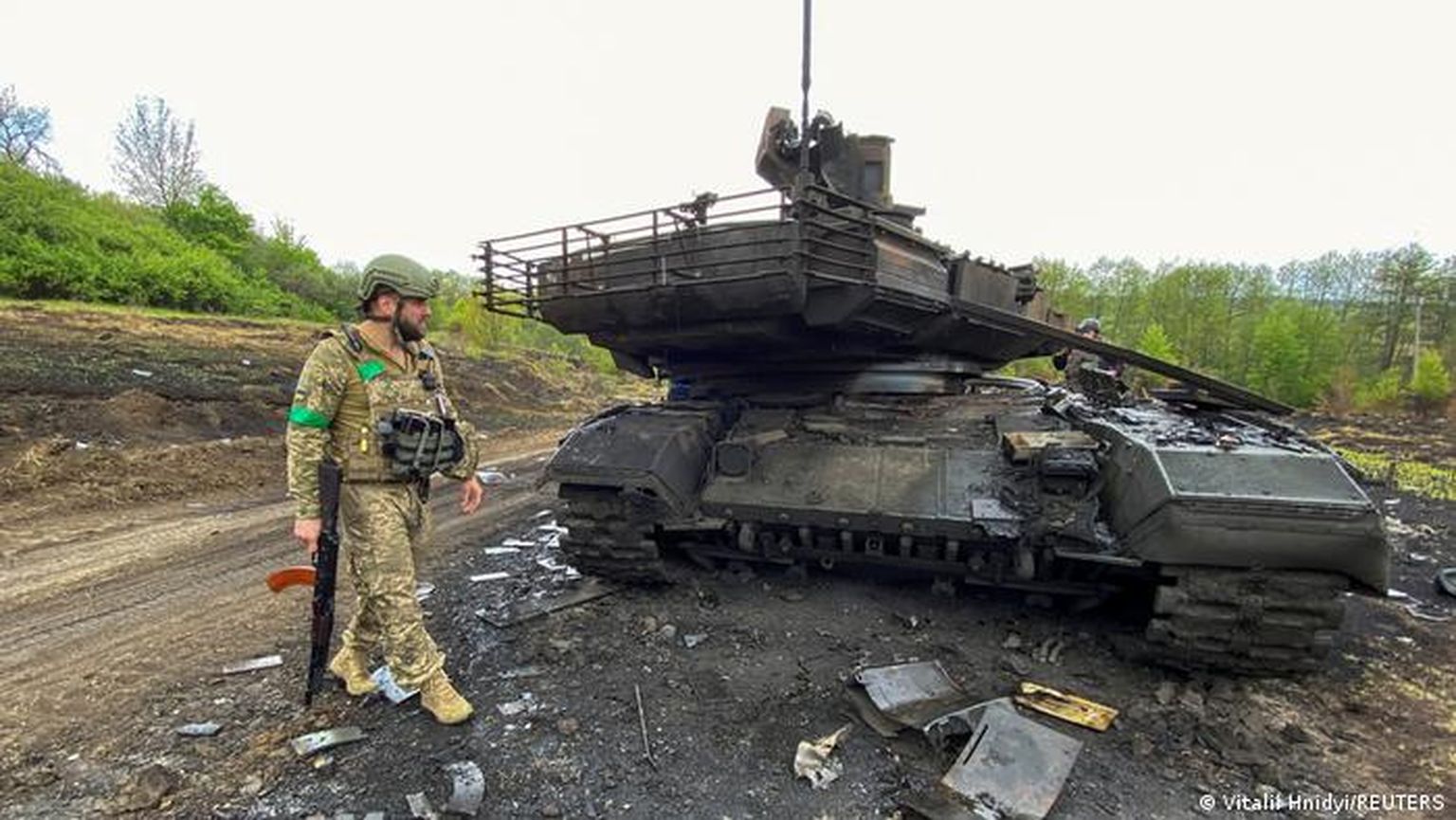 Украинский военный у уничтоженного российского танка Т-90М