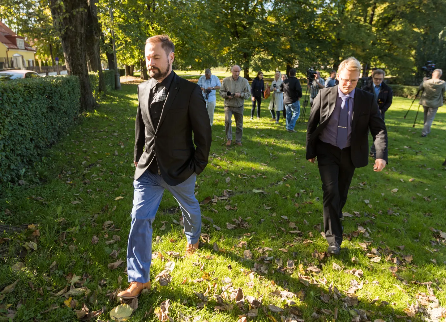 Juhtiv riigiprokurör Steven-Hristo Evestus (esiplaanil vasakul) vastas eile ajakirjanike küsimustele Edgar Savisaarele uue kahtlustuse esitamise kohta riigiprokuratuuri hoonest teisele poole teed jäävas pargis.