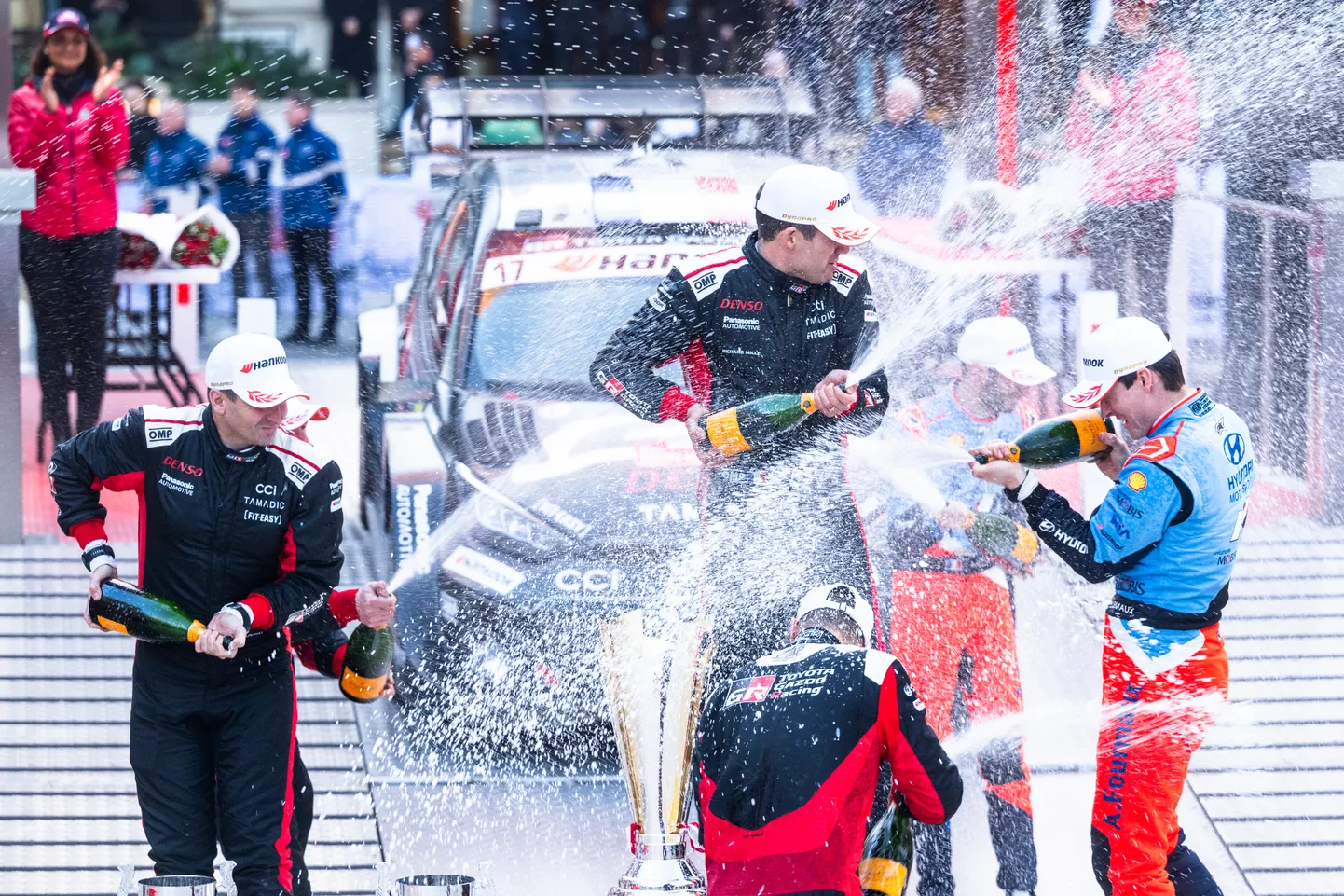 Monte Carlos ralli autasustamisel said šampust pritsida Sébastien Ogier (keskel), Elfyn Evans ja Adrien Fourmaux.