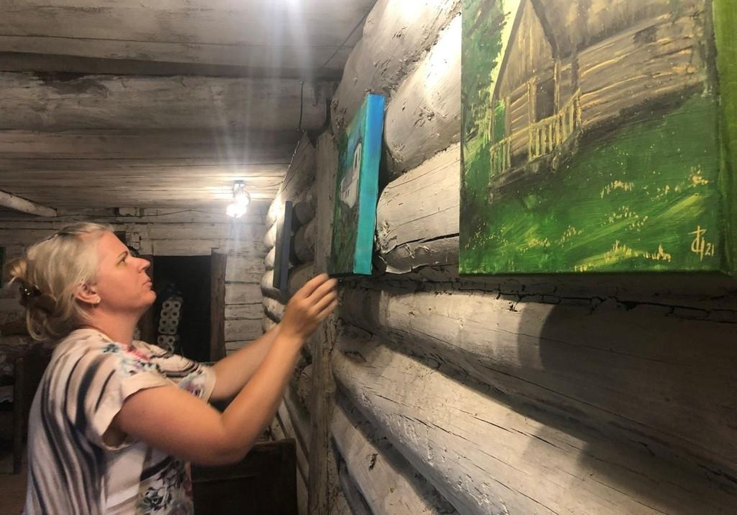 Maalija Ingrid Ulst sätib Filmi Vargamäel Mäe Andrese tagakambri seinale oma teoseid.