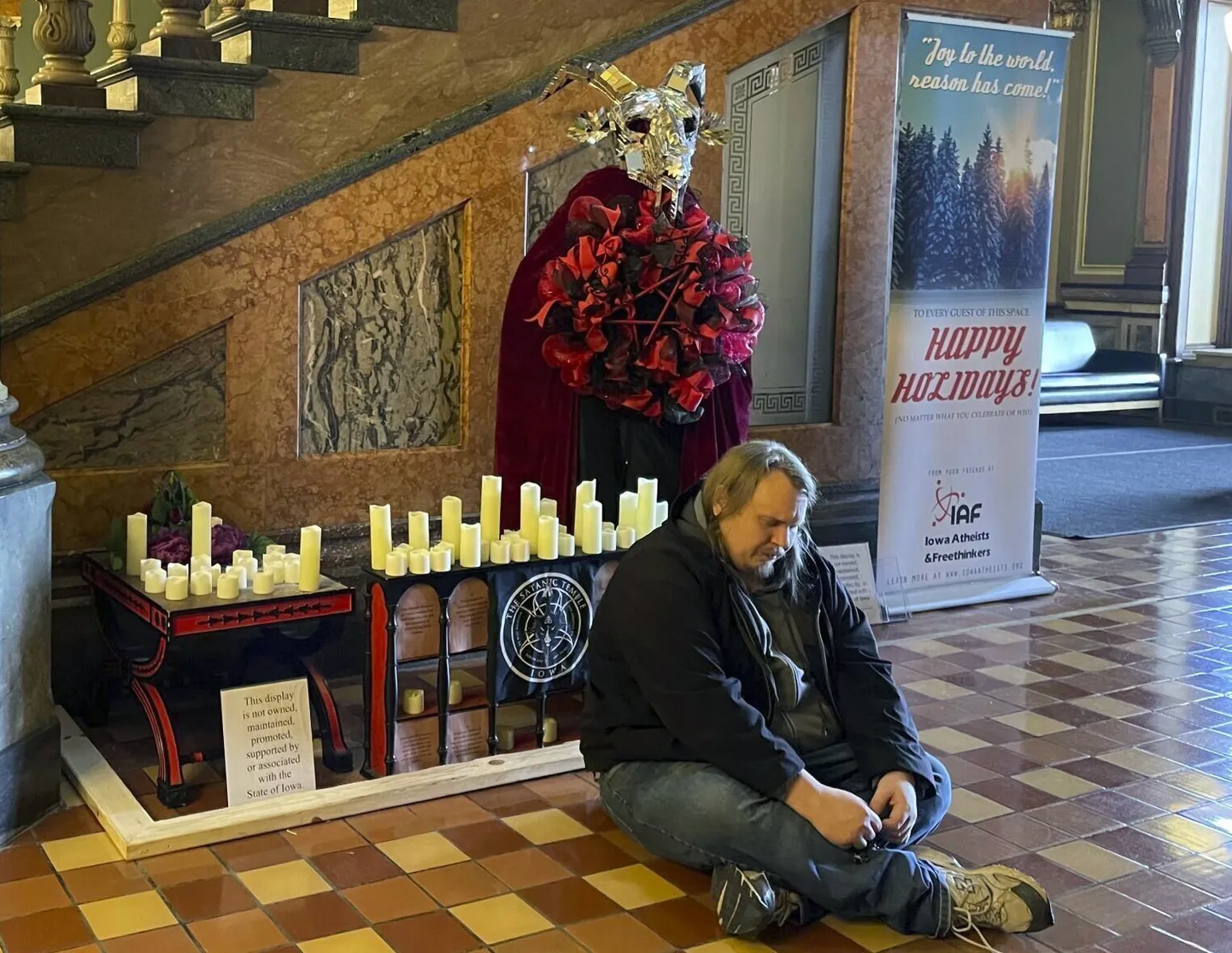 Mees palvetamas satanistliku templi altari ees Iowa osariigihoones 12. detsembril 2023. aastal.