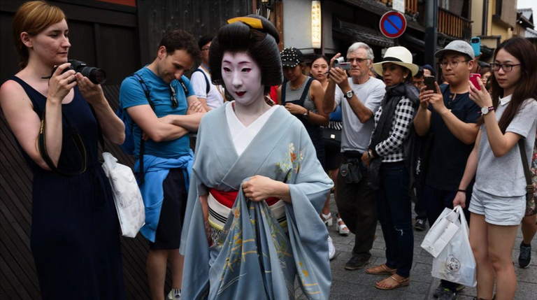 Туристы фотографируют гейшу