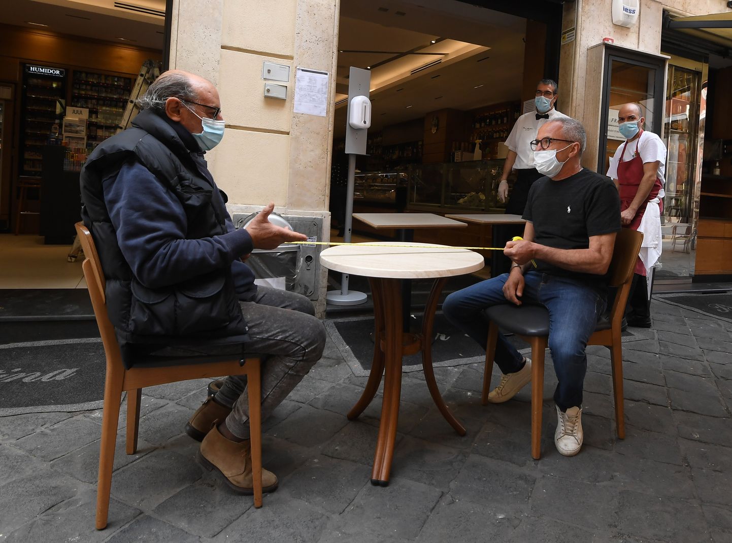 Kohviku töötajad kontrollivad Roomas enne kohviku avamist, kas laud on piisavalt suur sotsiaalse distantsi reegli täitmiseks.
