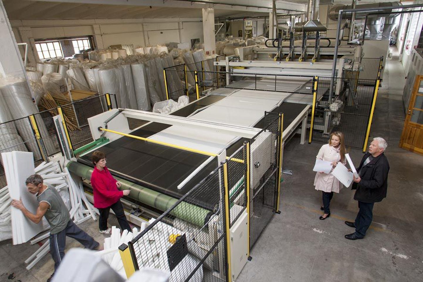 Toom Tekstiili müügijuht Maren Vahter ja nõukogu esimees Innar Susi (liini kõrval paremal) kinnitavad, et tekstiilijäätmete töötlemise tehas on alles käivitamise järgus ning mõne aja pärast võib sealsete masinate juures ametis olla praegusest poole rohkem inimesi.