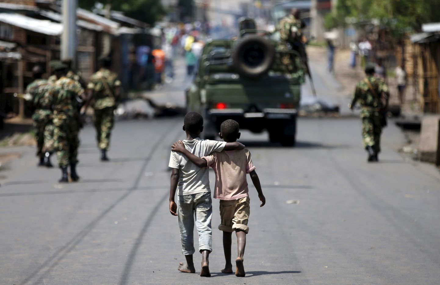 Poisid täna Burundis Bujumburas patrullivate politseinike taga kõndimas.
