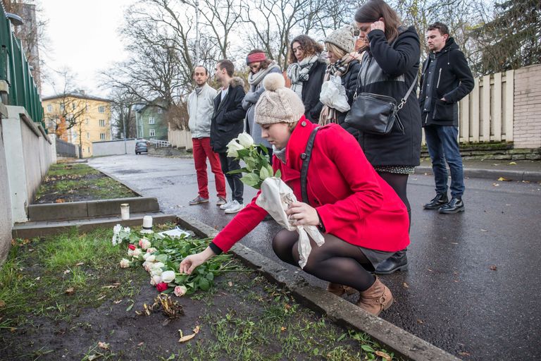 Жители Эстонии несут к французскому посольству в Таллинне цветы и свечи. 