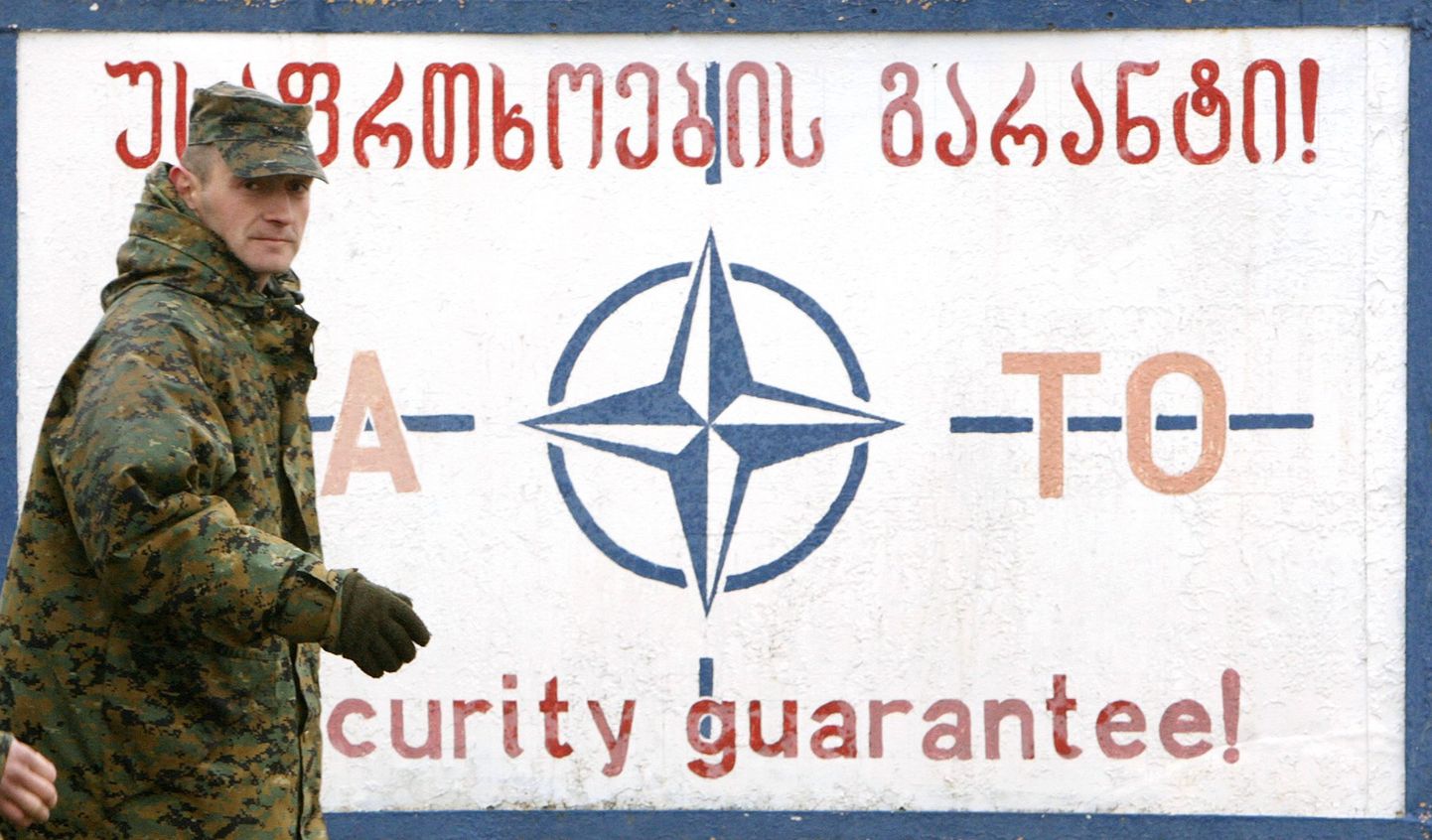 Gruusia sõdur möödumas NATO plakati eest.