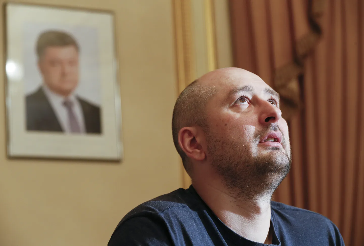 Vene ajakirjaik Arkadi Babtšenko pressikonverentsil Kiievis. Taustal on portree Ukraina presidendist Petro Porošenkost.