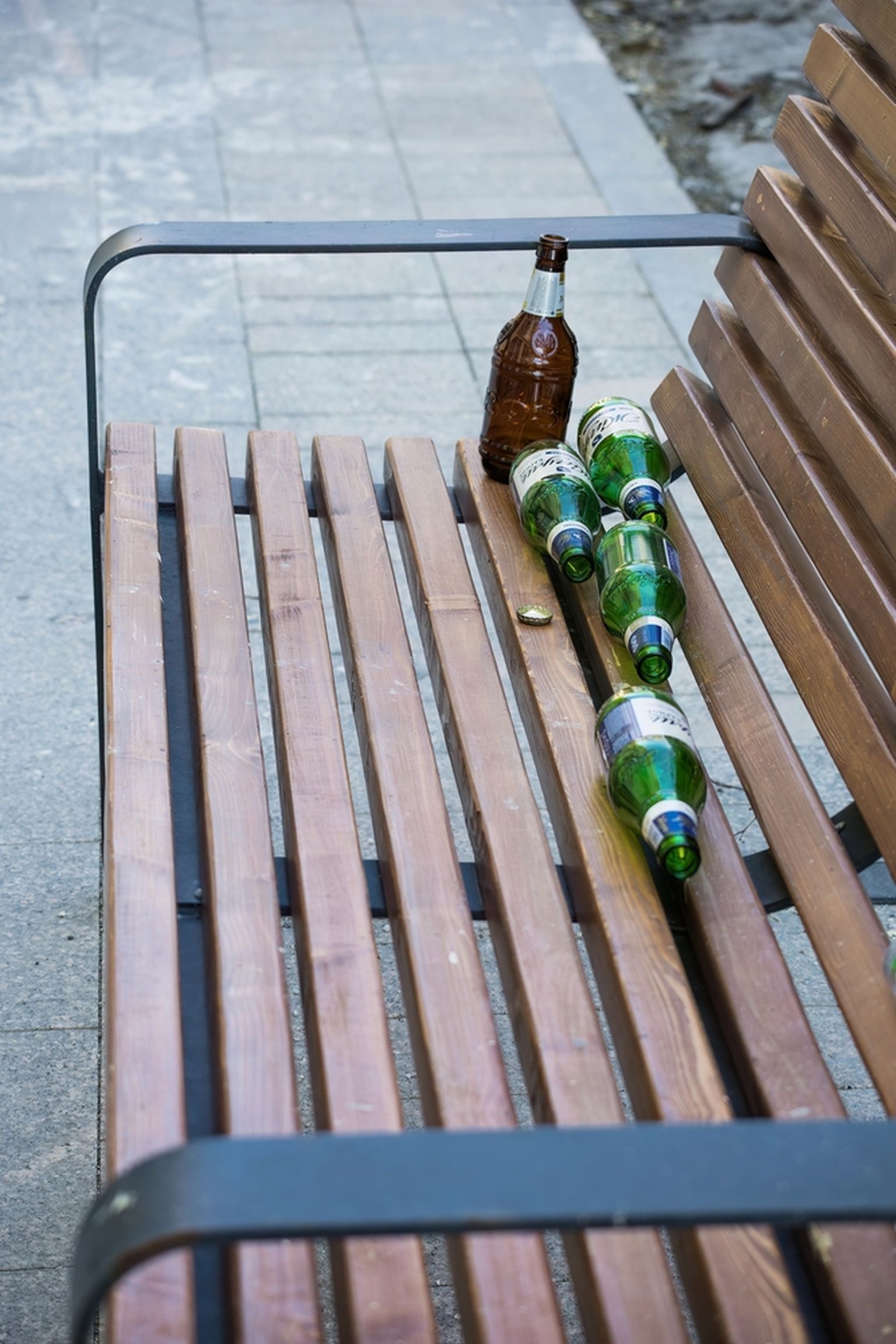 Бутылки на скамейки в парке. Фото иллюстративное.