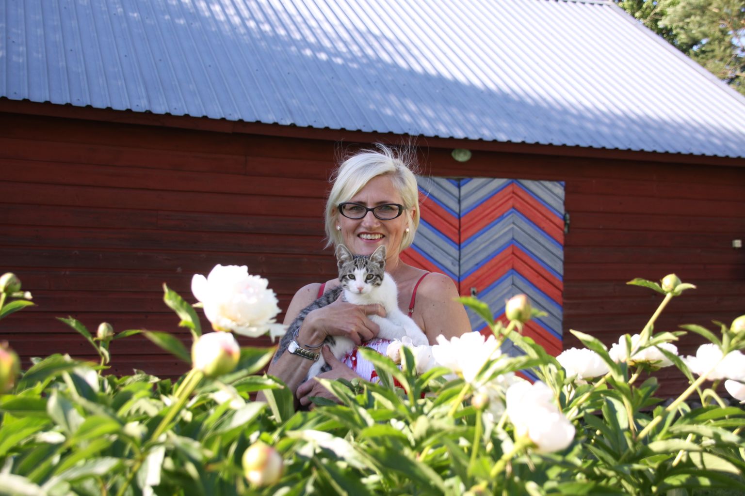 Uue-Kulli alu perenaine Annela Ojaste koondas pildile oma lemmikud: kass Oskari, põlvest-põlve hoitud pojengipõõsa ja kevadel Paide kihelkonna värvidesse võõbatud uksed.