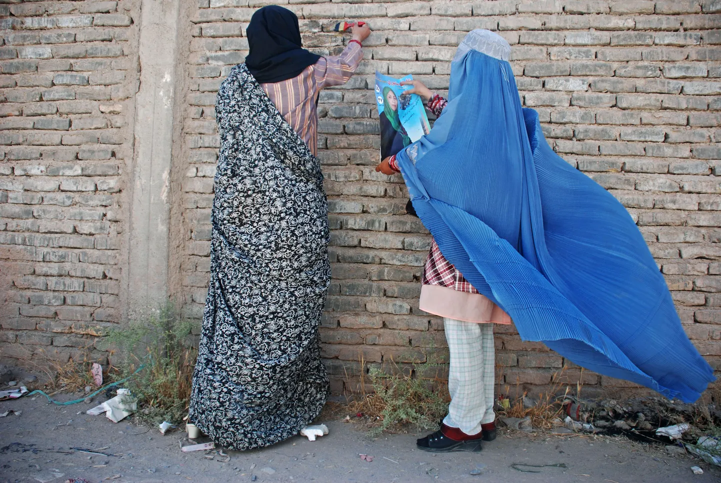 Herati naised kleepimas seinale naissoost saadikukandidaadi plakatit. Afganistani parlamendivalimised toimuvad 18. septembril.