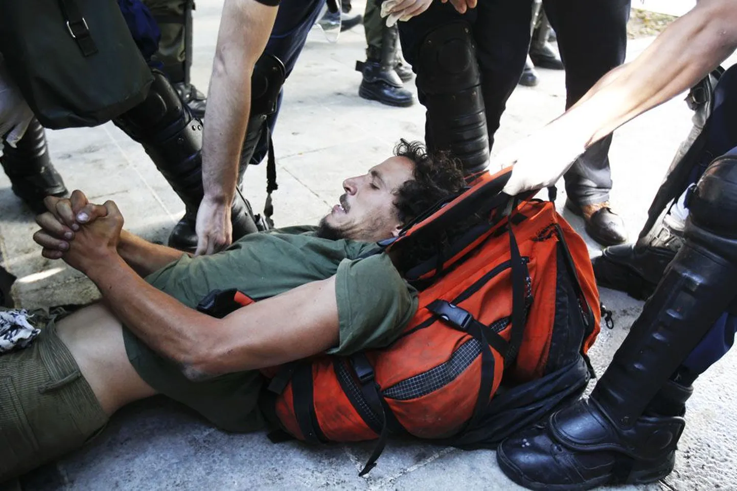 Politseinikud eile Ateenas kärpekavavastast protestijat politseibussi lohistamas.